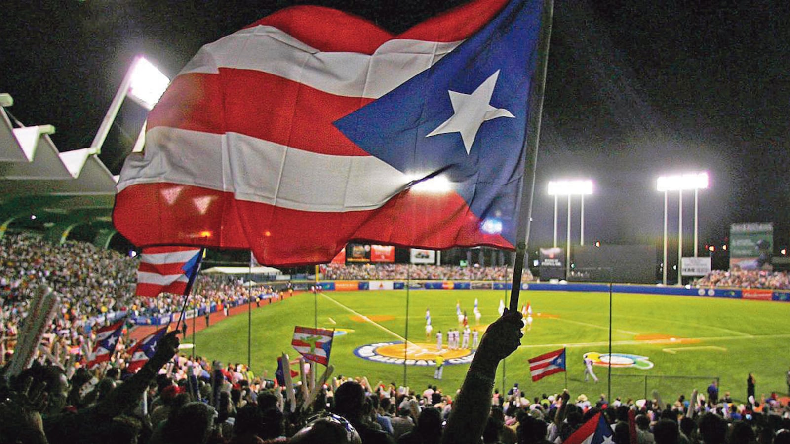 Puerto Rico se prepara para el Clásico Mundial de Béisbol. Bandera de Puerto Rico es ondeada desde las gradas en el estadio de béisbol