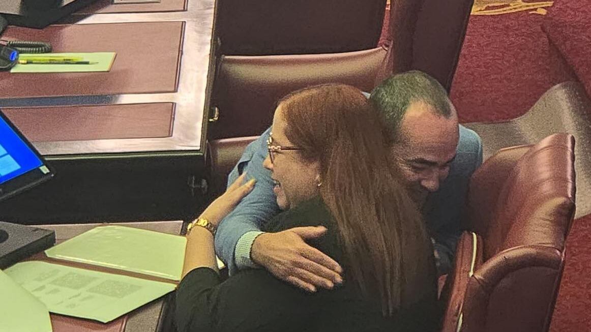 El senador abrazando a la senadora del PNP, Karen Román.
