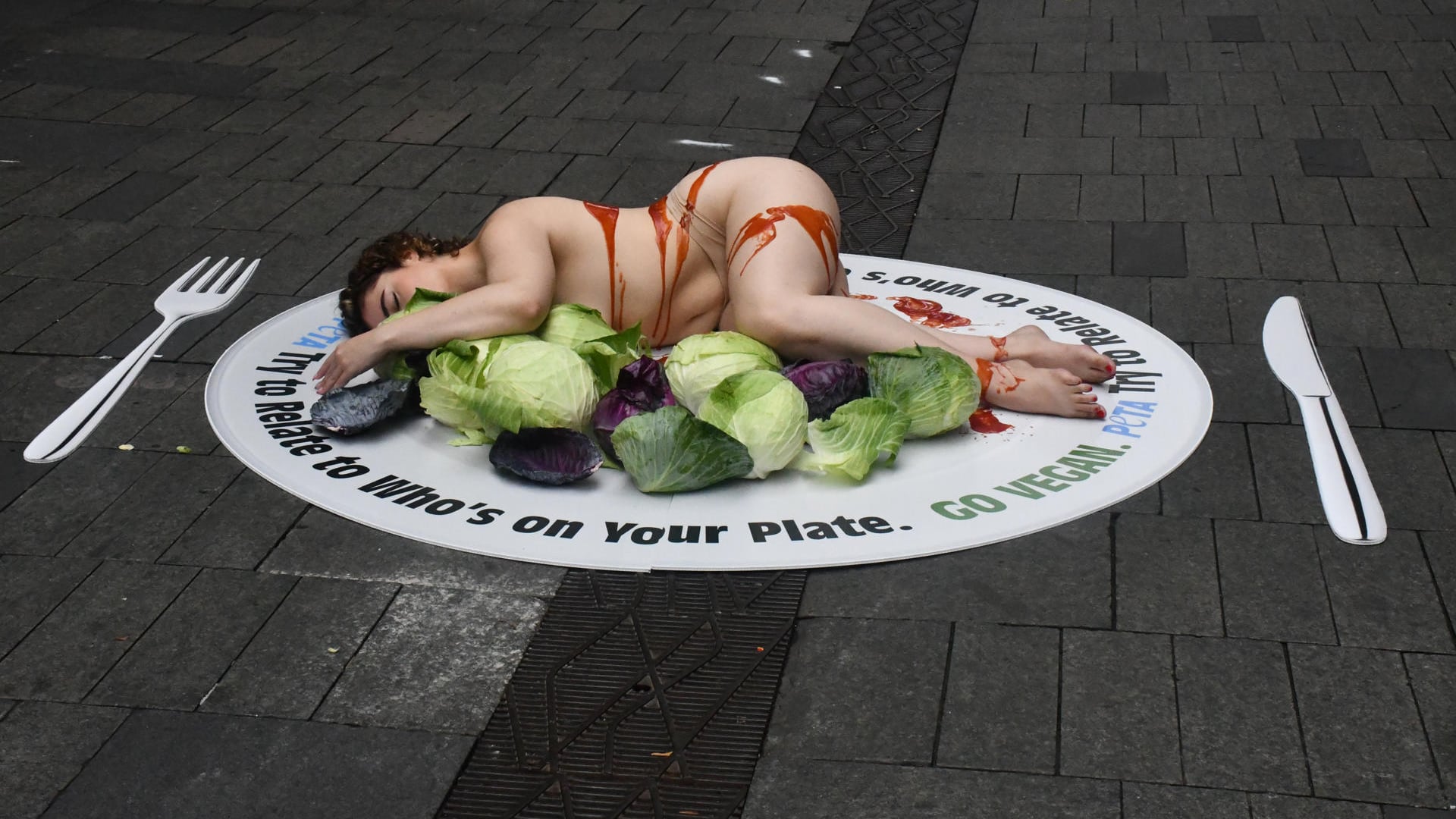SÍDNEY (Australia), 18/03/2026.- La organización animalista PETA celebra este miércoles una protesta en el centro de Sídney en la que una modelo posó sobre un gran plato junto a un cuchillo y tenedor para hacer reflexionar a la ciudadanía sobre el consumo de animales, en un país con una de las industrias cárnicas más grandes del mundo. EFE/ Edurne Morillo