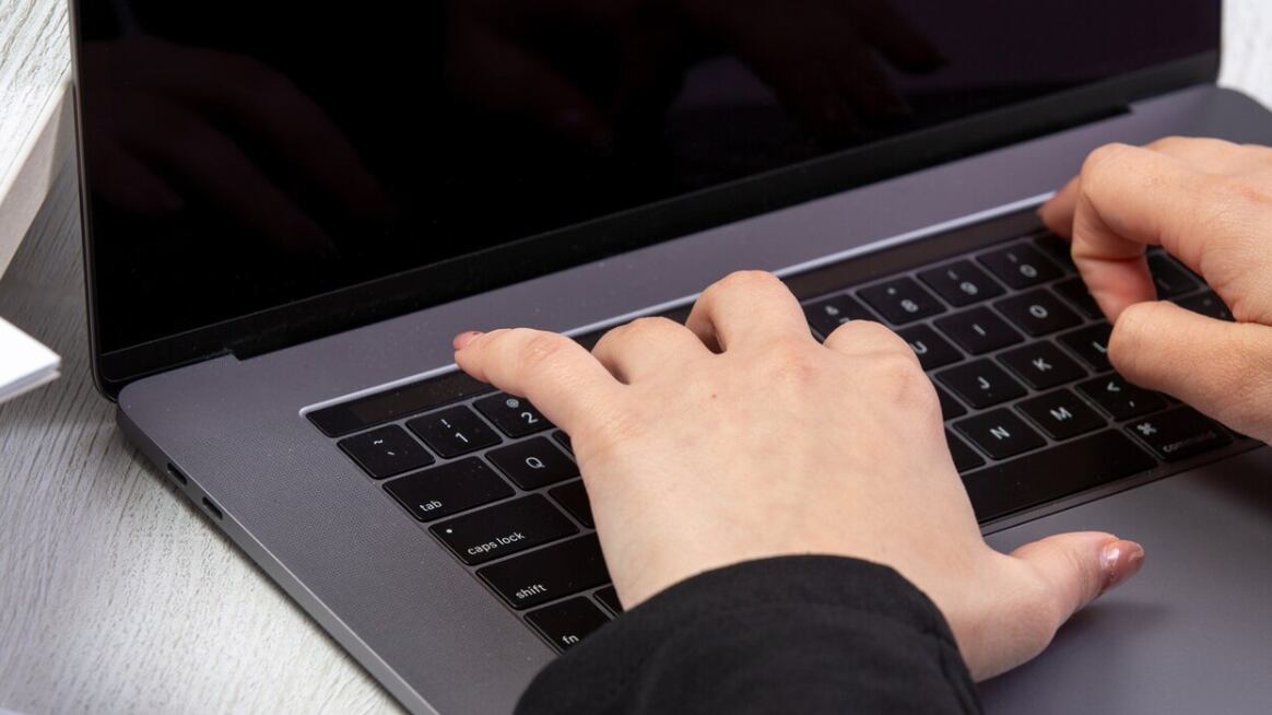 Una chica de vista frontal usando una computadora portátil frente a la mesa usando una actividad comercial