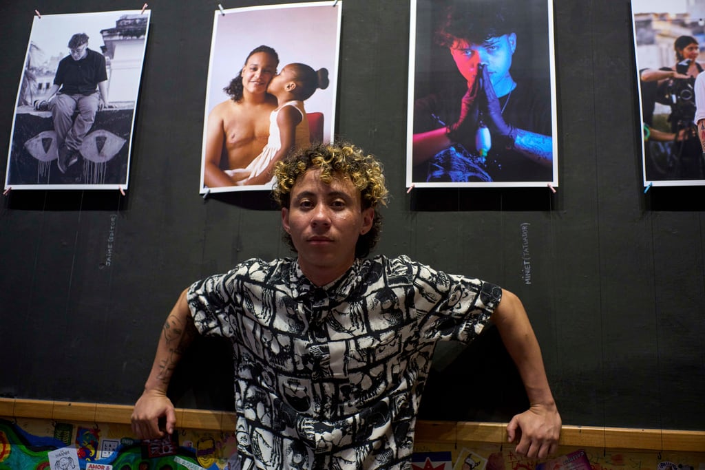 Merle Ramírez, un hombre transgénero, posa junto a sus retratos de cubanos transgénero en su exposición en la galería La Marca en La Habana, el viernes 4 de abril de 2025. (AP Foto/Ramón Espinosa)