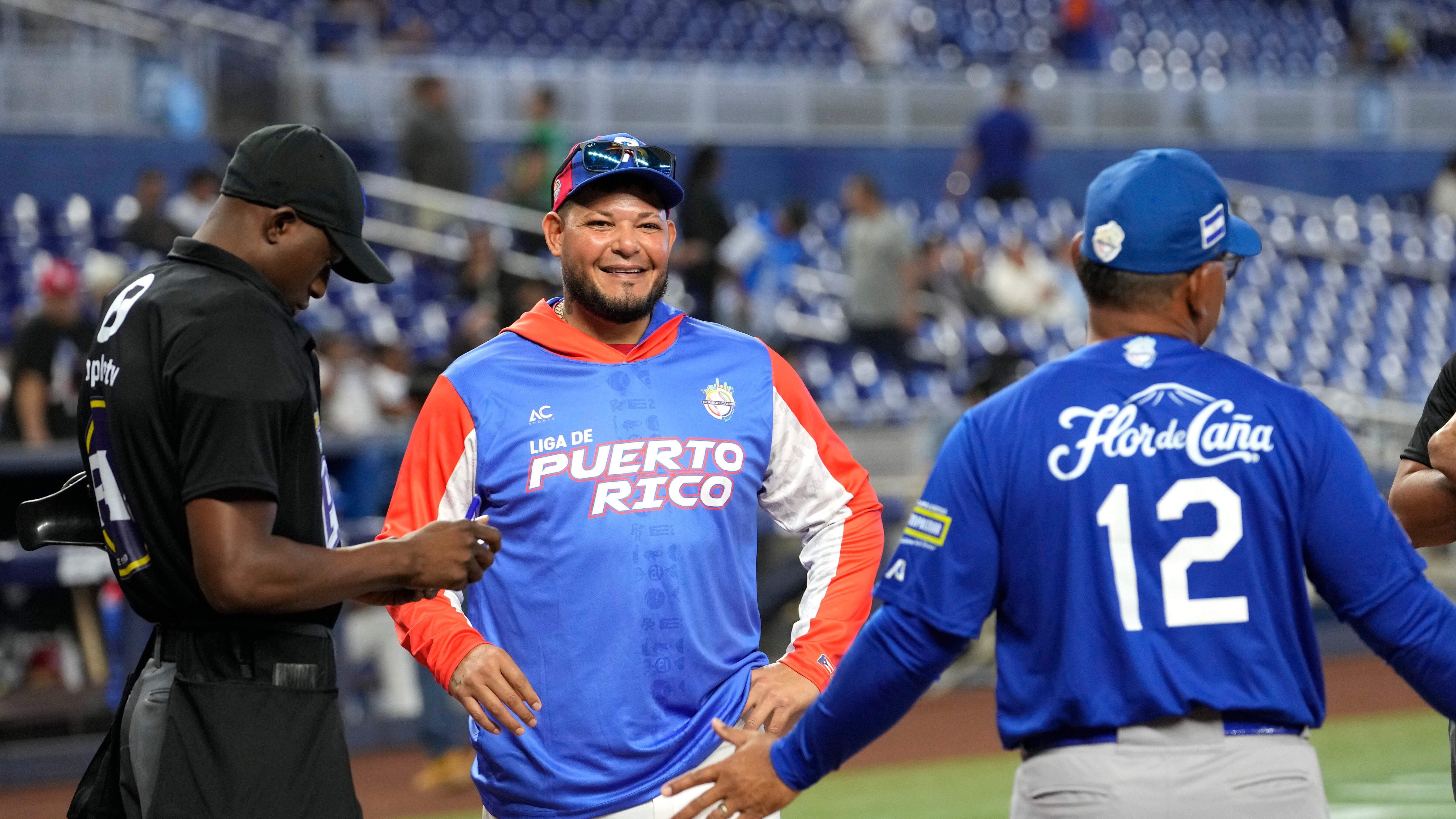Puerto Rico manager Yadier Molina, center, stands at the mound with Nicaragua manager Marvin Benard (12) before a Caribbean Series baseball game, Thursday, Feb. 1, 2024, in Miami. (AP Photo/Lynne Sladky)