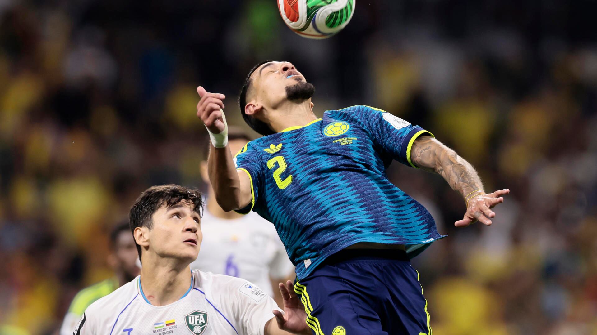 Daniel Muñoz (d) de Colombia cabecea un balón este miércoles, en un partido del grupo K del Mundial de la FIFA 2026 entre Uzbekistán y Colombia, en el estadio Azteca en Ciudad de México (México). EFE/ José Méndez