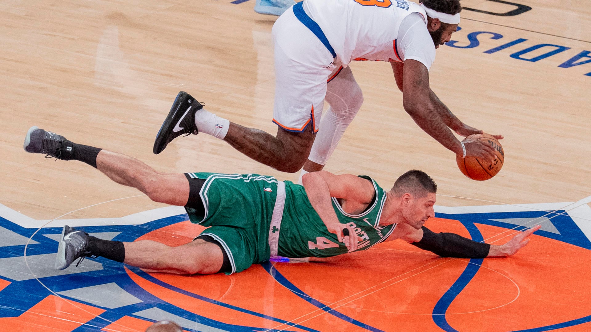 Mitchell Robinson (arriba) de los Knicks, disputa el balón con Anfernee Simons (abajo), de los Celtics en el Madison Square Garden en Nueva York. EFE/Angel Colmenares