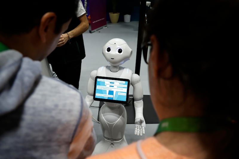 Unos visitantes hablan con el robot 'Pepper' en una imagen de archivo de una feria. EFE/EPA/SEBASTIEN NOGIER