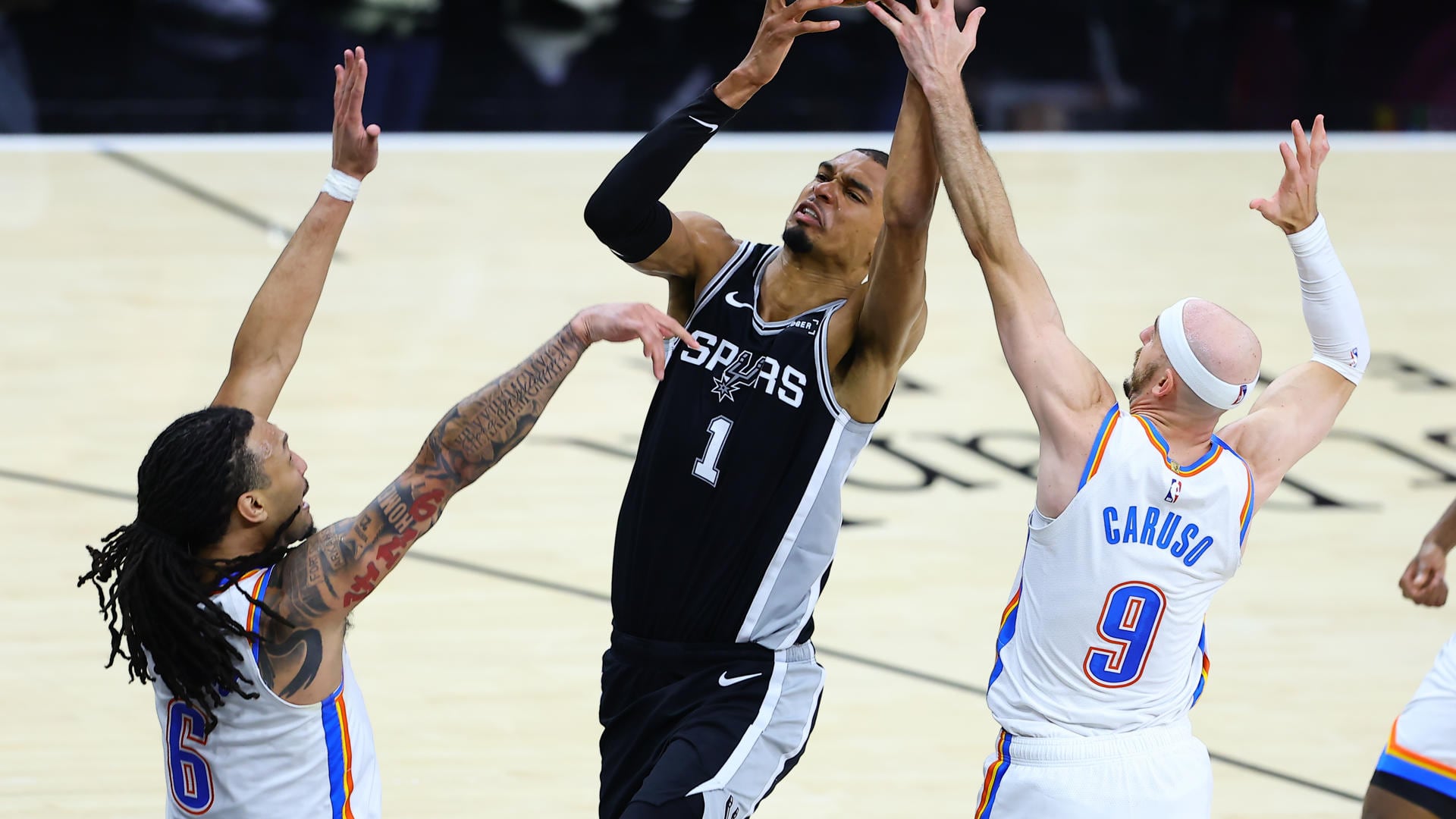 Victor Wembanyama (c), de Spurs, disputa un balón con Alex Caruso (d) y Jaylin Williams, de Thunder, en un partido de la NBA en el AT&T Center en San Antonio (EE.UU.). EFE/Carlos Ramírez