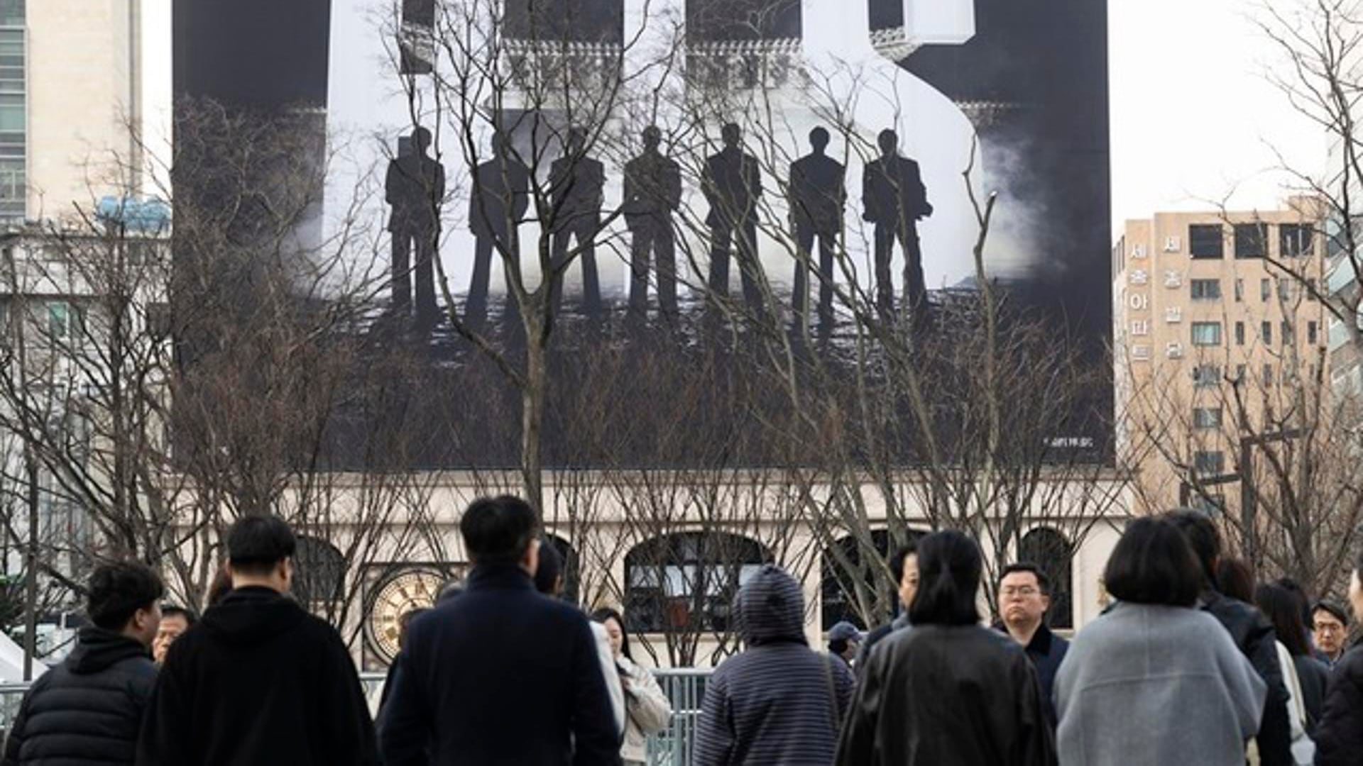 Seúl, 20/03/2026.- Varias personas caminan cerca del escenario principal para presenciar un concierto gratuito del grupo de K-pop BTS en la plaza Gwanghwamun de Seúl, Corea del Sur, el 20 de marzo de 2026. EFE/EPA/JEON HEON-KYUN