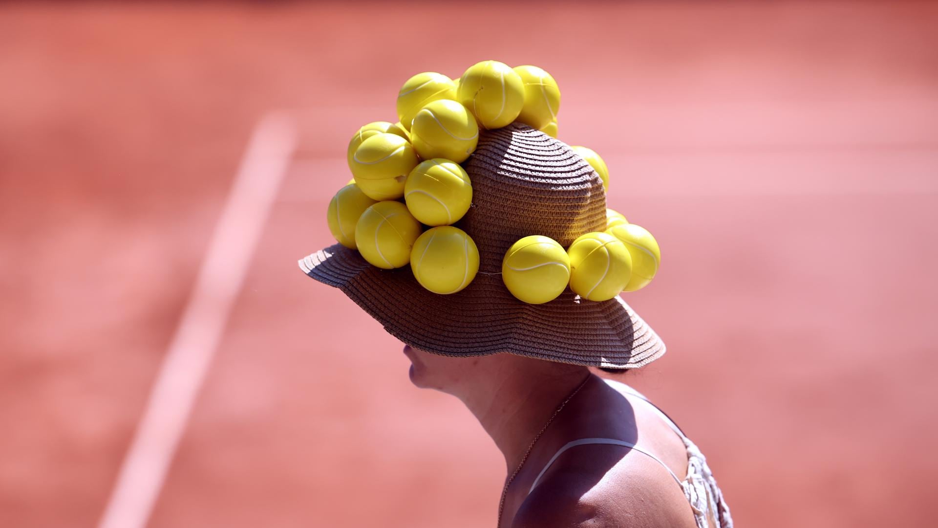 Una espectadora lleva un sombrero adornado con bolas de tenis durante un partido del Roland Garros. EFE/EPA/CHRISTOPHE PETIT TESSON