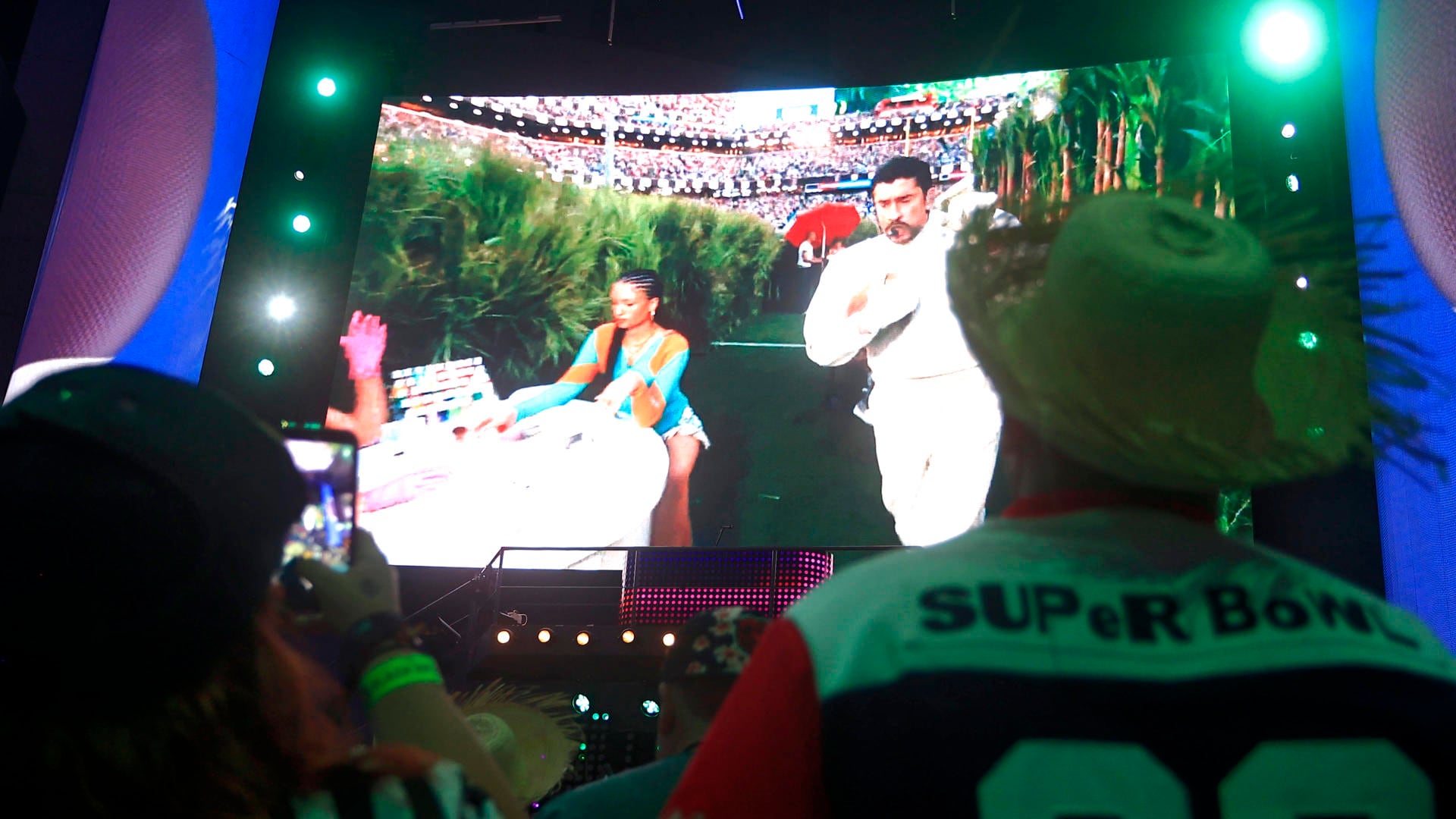 Personas observan la transmisión del espectáculo del cantante Bad Bunny en el Super Bowl de Estados Unidos este domingo, en San Juan (Puerto Rico). EFE/ Thais Llorca